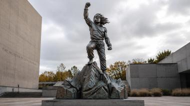 Statues of men Man with raised fist on rock peak 3d model